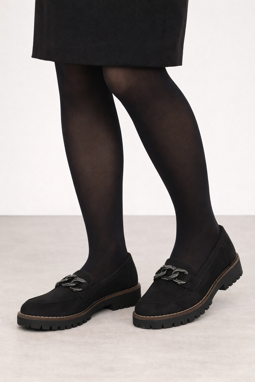Black chunky chain loafers worn with black tights